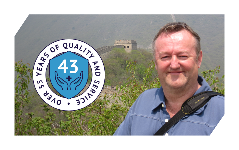 A Man standing with the great wall of China in the background